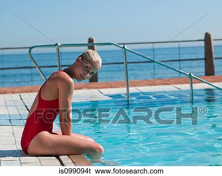 Young woman sitting at poolside, portrait View Large Photo Image Stock Photograph - Young woman sitting at poolside, portrait. Fotosearch