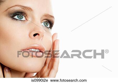 Stock Image - Young woman touching her face. Fotosearch
