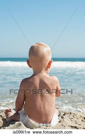 Stock Image - Baby sitting by the sea. Fotosearch
