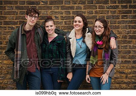 Four young friends against brick wall, smiling View Large Photo Image Stock Photography - Four young friends against brick wall, smiling. Fotosearch