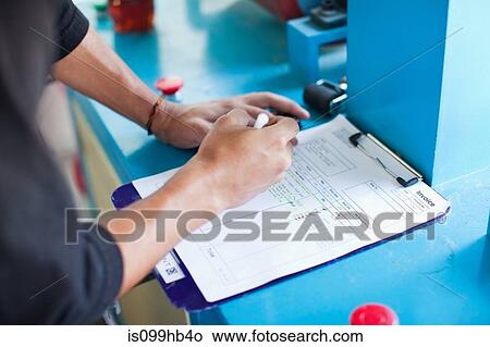 Man checking off items on an invoice View Large Photo Image Picture - Man checking off items on an invoice. Fotosearch