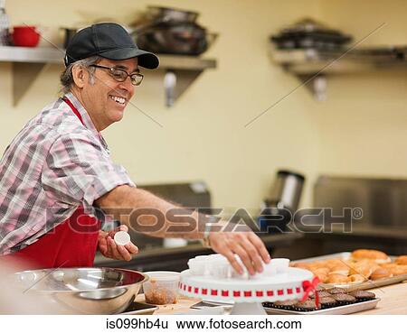 Mature baker preparing food in kitchen View Large Photo Image Stock Photograph - Mature baker preparing food in kitchen. Fotosearch