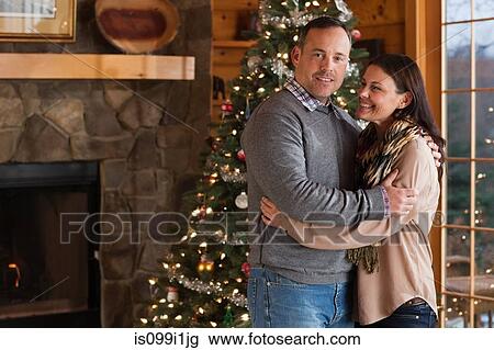 Mature couple embracing by Christmas tree, portrait View Large Photo Image Stock Image - Mature couple embracing by Christmas tree, portrait. Fotosearch