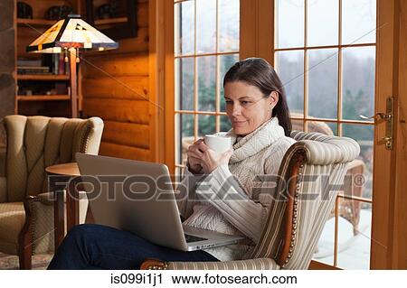 Mature woman relaxing in armchair with laptop View Large Photo Image Stock Image - Mature woman relaxing in armchair with laptop. Fotosearch