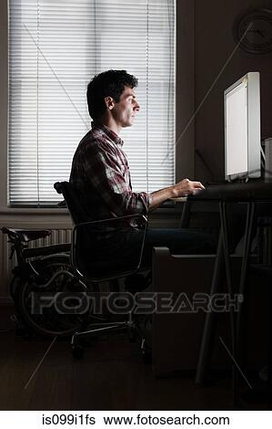 Mid adult man using home computer at desk View Large Photo Image Stock Photograph - Mid adult man using home computer at desk. Fotosearch