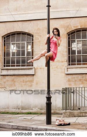 Mid adult woman in pink dress using cellphone on street lamp in city View Large Photo Image Stock Photograph - Mid adult woman in pink dress using cellphone on street lamp in city. Fotosearch