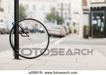 Single bicycle wheel secured to lamp post View Large Photo Image Stock Image - Single bicycle wheel secured to lamp post. Fotosearch