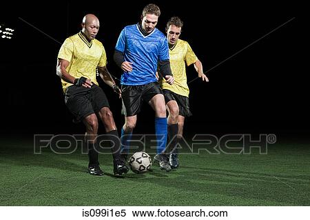 Stock Photography - Soccer players tackling on pitch. Fotosearch