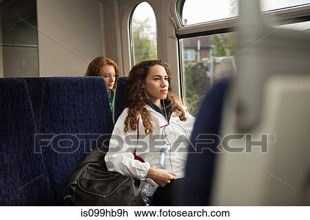 Two young women travelling on train View Large Photo Image Stock Image - Two young women travelling on train. Fotosearch