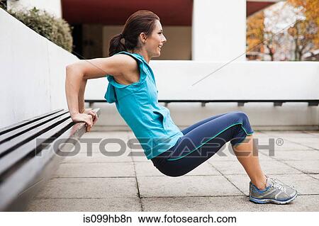 Woman in sportswear performing tricep dips View Large Photo Image Picture - Woman in sportswear performing tricep dips. Fotosearch