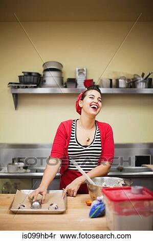 Young baker laughing while preparing food View Large Photo Image Stock Photography - Young baker laughing while preparing food. Fotosearch