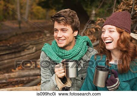 Young couple in forest holding flasks View Large Photo Image Stock Image - Young couple in forest holding flasks. Fotosearch