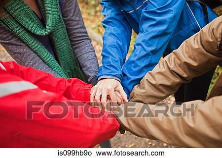 Picture - Young friends holding hands together. Fotosearch