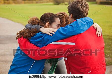 Young friends huddling together in park View Large Photo Image Stock Photography - Young friends huddling together in park. Fotosearch