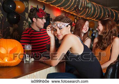 Stock Image - Young friends sitting in bar. Fotosearch