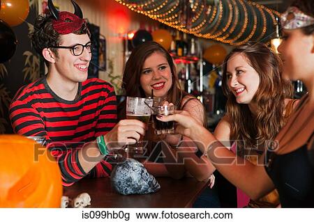 Young friends toasting drinks in bar View Large Photo Image Stock Image - Young friends toasting drinks in bar. Fotosearch