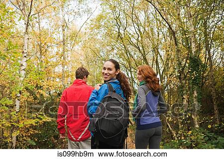 Picture - Young friends walking into forest. Fotosearch