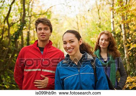 Picture - Young friends walking into forest. Fotosearch