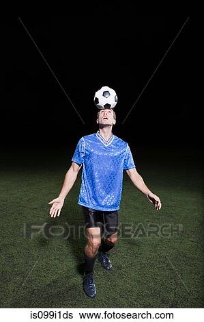 Young man heading soccer ball on pitch View Large Photo Image Stock Photograph - Young man heading soccer ball on pitch. Fotosearch