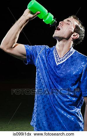 Young soccer player drinking water on pitch View Large Photo Image Stock Photo - Young soccer player drinking water on pitch. Fotosearch