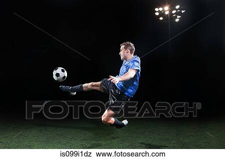 Young soccer player leaping into air to kick ball View Large Photo Image Stock Photo - Young soccer player leaping into air to kick ball. Fotosearch