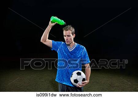 Young soccer player pouring water of himself on pitch View Large Photo Image Stock Photo - Young soccer player pouring water of himself on pitch. Fotosearch