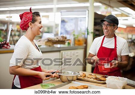 Young woman and man laughing in commercial kitchen View Large Photo Image Stock Photo - Young woman and man laughing in commercial kitchen. Fotosearch