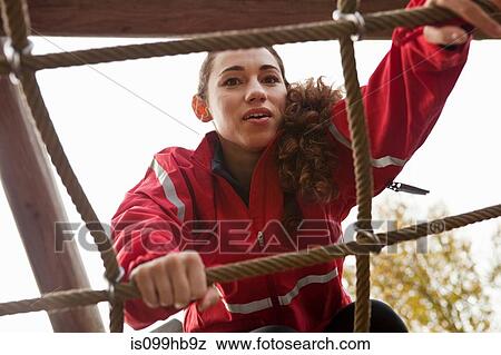 Young woman climbing assault course equipment View Large Photo Image Stock Photo - Young woman climbing assault course equipment. Fotosearch