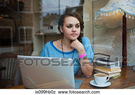 Young woman in cafe using laptop View Large Photo Image Stock Photo - Young woman in cafe using laptop. Fotosearch