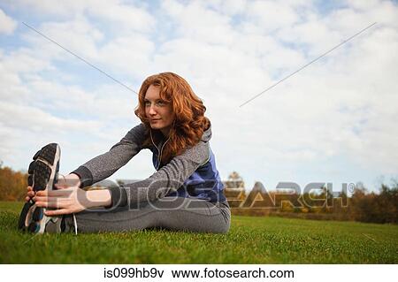 Young woman performing stretches in park View Large Photo Image Stock Photo - Young woman performing stretches in park. Fotosearch