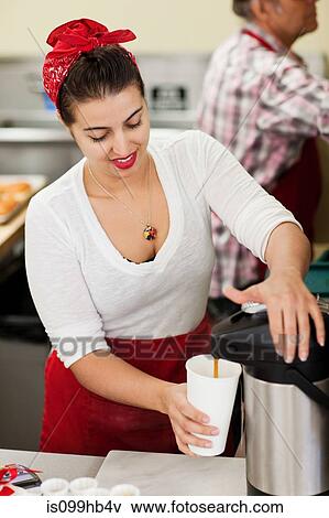 Young woman pouring fresh coffee into disposable cup View Large Photo Image Stock Photo - Young woman pouring fresh coffee into disposable cup. Fotosearch