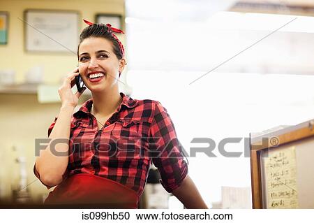 Young woman taking a phone call in bakery View Large Photo Image Stock Image - Young woman taking a phone call in bakery. Fotosearch