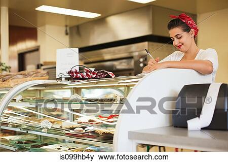 Young woman working on counter of bakery View Large Photo Image Stock Photo - Young woman working on counter of bakery. Fotosearch
