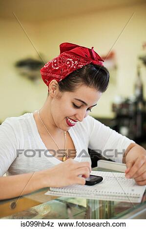 Stock Photo - Young woman working on counter of bakery. Fotosearch