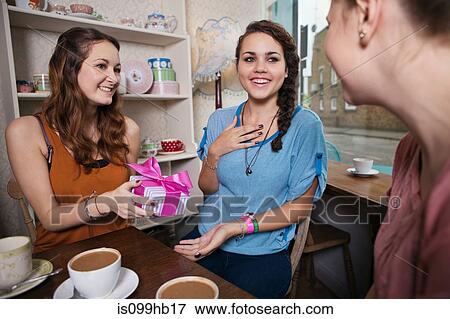Young women giving friend a brithday gift View Large Photo Image Stock Photo - Young women giving friend a brithday gift. Fotosearch