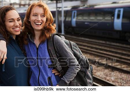 Young women smiling at train station View Large Photo Image Stock Image - Young women smiling at train station. Fotosearch
