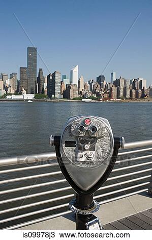 Stock Image - Coin operated binoculars overlooking East River towards Manhattan, New York. Fotosearch