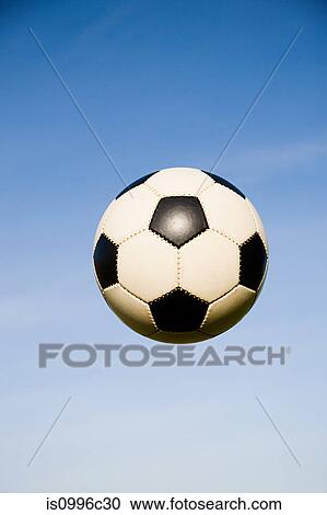 Stock Image - Football mid air. Fotosearch