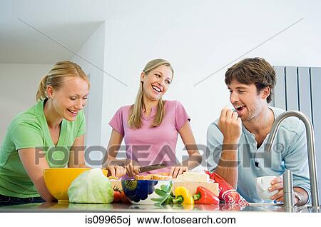 Friends preparing food in kitchen View Large Photo Image Stock Image - Friends preparing food in kitchen. Fotosearch
