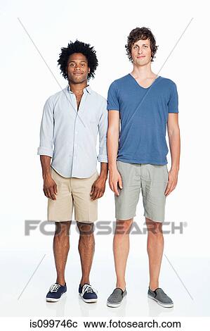 Stock Image - Gay couple standing against white background. Fotosearch
