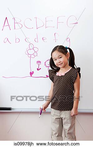 Stock Image - Girl in front of whiteboard with alphabet. Fotosearch