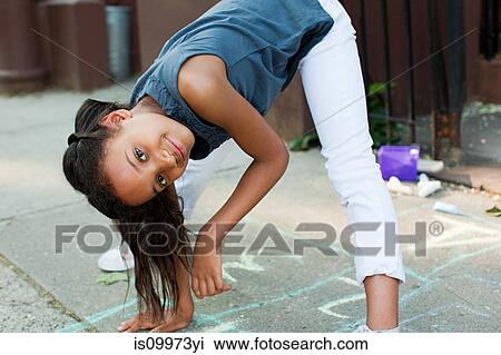 Girl playing on sidewalk, smiling View Large Photo Image Stock Image - Girl playing on sidewalk, smiling. Fotosearch