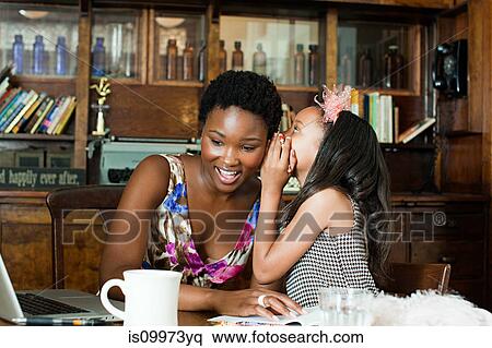 Girl whispering to mother at table View Large Photo Image Stock Photography - Girl whispering to mother at table. Fotosearch