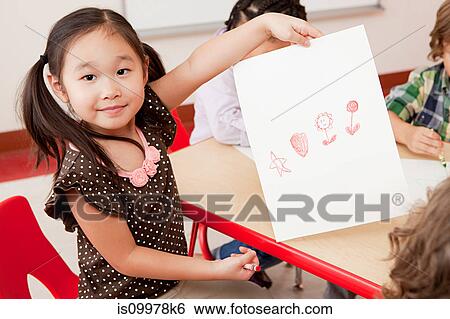 Girl with a crayon drawing View Large Photo Image Stock Photograph - Girl with a crayon drawing. Fotosearch