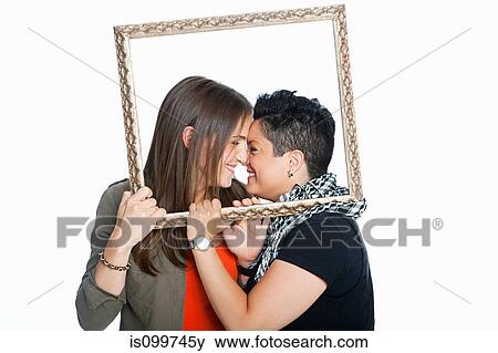 Lesbian couple holding picture frame against white background View Large Photo Image Stock Photo - Lesbian couple holding picture frame against white background. Fotosearch