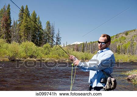 Stock Image - Man fly fishing in river, Colorado, USA. Fotosearch