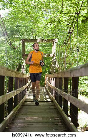 Man running along boardwalk View Large Photo Image Stock Photograph - Man running along boardwalk. Fotosearch