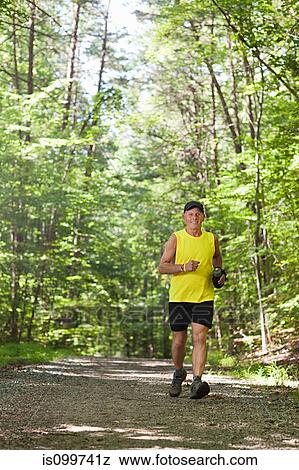 Stock Photo - Man running along forest path. Fotosearch