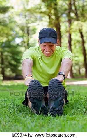 Man stretching on grass View Large Photo Image Stock Photo - Man stretching on grass. Fotosearch