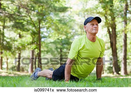 Man stretching on grass View Large Photo Image Stock Photo - Man stretching on grass. Fotosearch